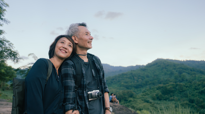 Older couple smiling and enjoying a beautiful view.