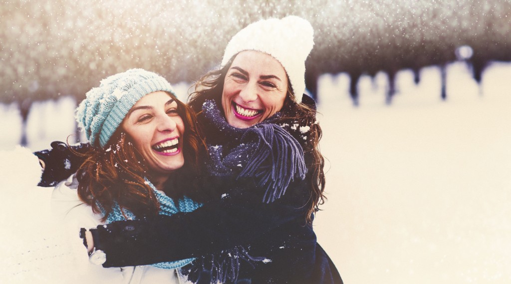 two smiling women hugging in the snow - Delta Dental of Colorado Blog