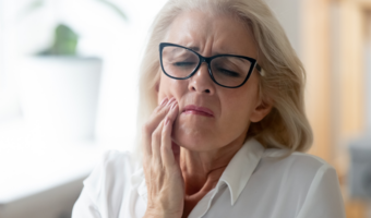 Person holding their mouth in pain.