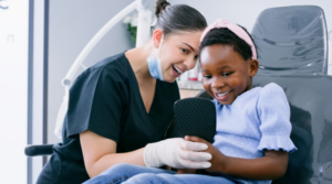 Dental assistant with child patient in the dental office.