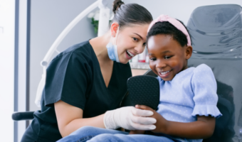 Dental assistant with child patient in the dental office.