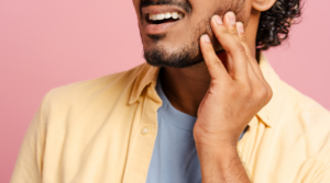 Person holding their jaw in pain.