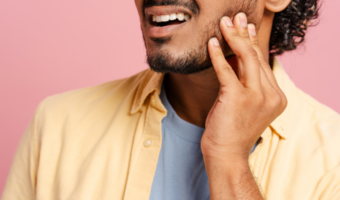 Person holding their jaw in pain.