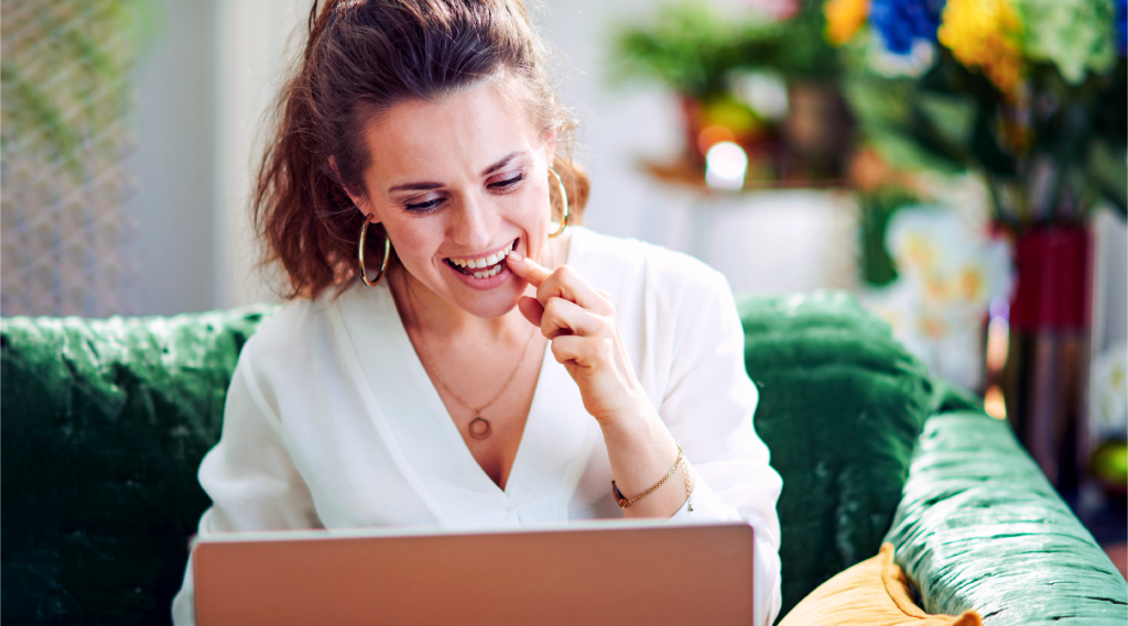 Woman smiles while looking at computer screen