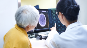 Older adult looking at a brain scan with a doctor.