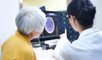 Older adult looking at a brain scan with a doctor.