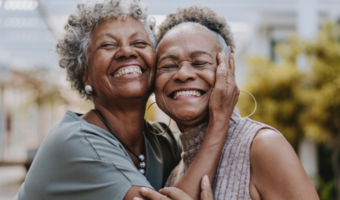 Two people smiling and holding each other.