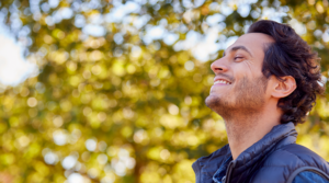 Person smiling in the sun outside.