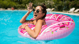 Person smiling and swimming in a pool.