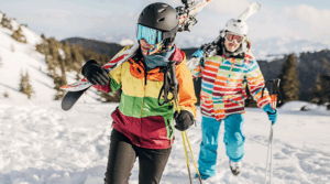 Two people hiking up the mountain in ski gear.