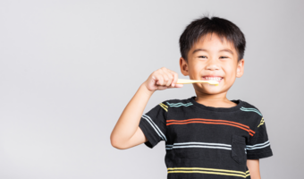 Child smiling and brushing his teeth.