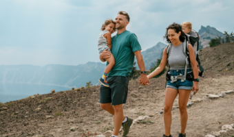 Couple smiling and hiking with their children.