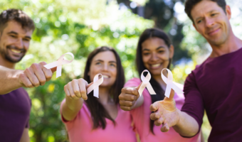 Group of people holding up breast cancer awareness ribbons.