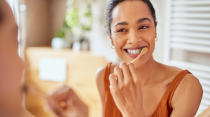 Person smiling and brushing their teeth.