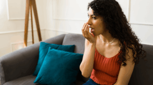 Person holding their hand to their mouth, smelling their breath.