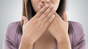 Person covering their mouth with their hands.