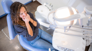 Person covering their mouth at the dentist.