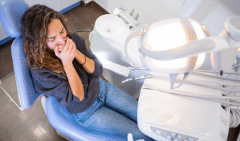 Person covering their mouth at the dentist.