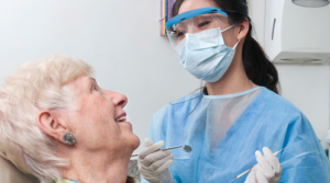 Older adult getting an oral health exam from a dentist.