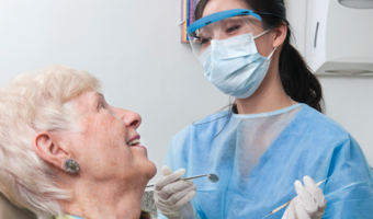 Older adult getting an oral health exam from a dentist.