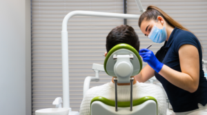 Patient getting a dental exam from a dental assistant.