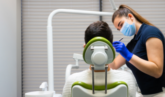 Patient getting a dental exam from a dental assistant.